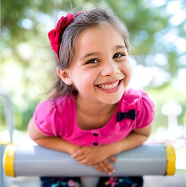 Littler girl smiling on outdoor playground
